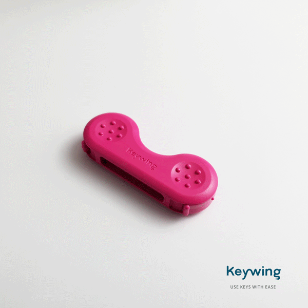 The pink Keywing key turner being opened and closed showing a the removal of the 3M adhesive and insertion of a key.